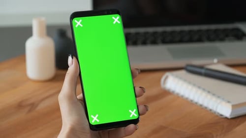 Person, die Handy mit Greenscreen-Display in der Hand benutzt, und Frau machen eine Geste. Nahaufnahme-Konzept...