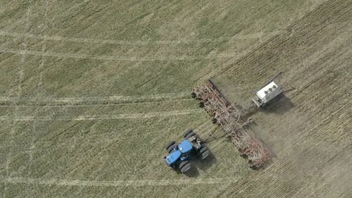 Aerial View of Farmer Seeding and Sowing Fields with Tractor