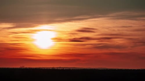 Sunset Moving Down Over the Horizon Through Clouds in Orange Sky Timelapse