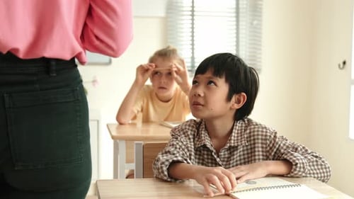 Children sitting at desks in classroom, elementary school