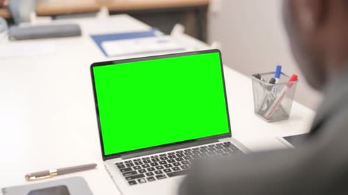 Close up of African Businessman Working on Green Screen Laptop