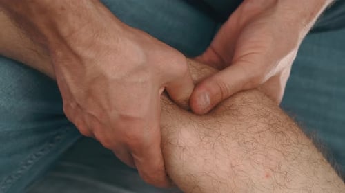 Man Kneading Calf Man Uses Hands To Knead And Apply Pressure To Calf Muscle For Recovery