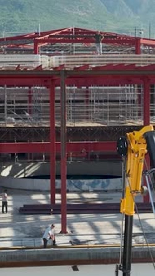 Construcción vertical en vídeo de un enorme centro comercial que carga material en los pisos superiores