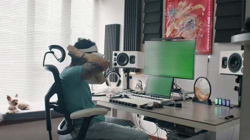 Man Using VR Headset at Computer Workstation