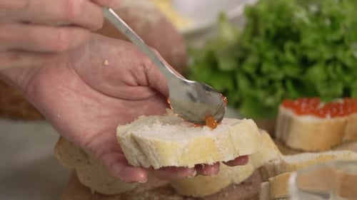 Preparing Caviar Appetizer on Fresh Bread Slice