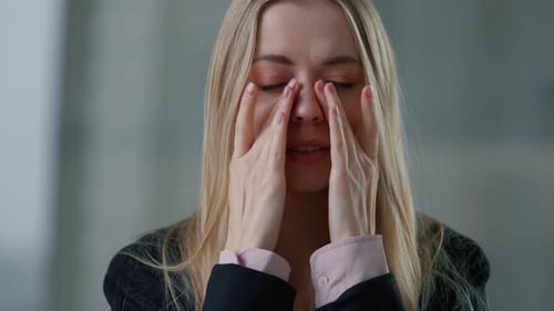 Blonde Woman Expressing Discomfort and Rubbing Her Eyes