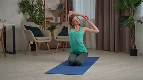 Woman Kneels and Stretches in Bright Room