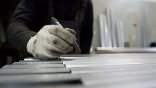 The Engineer Marks the Length of Metal Structures in the Workshop with a Marker