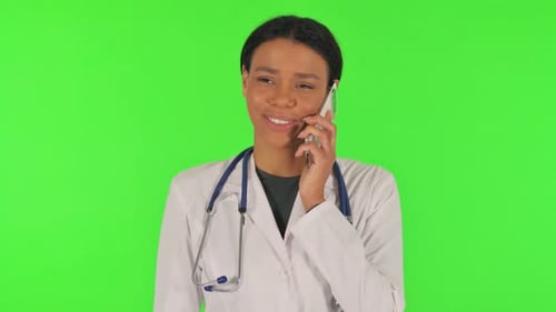 Portrait of Female Doctor Talking on phone on green background
