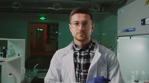 Close Up Handsome Cheerful Scientist with Glasses and Protective Gloves in a White Medical Uniform