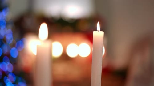 Candles Burning in Front of Defocused Christmas Lights