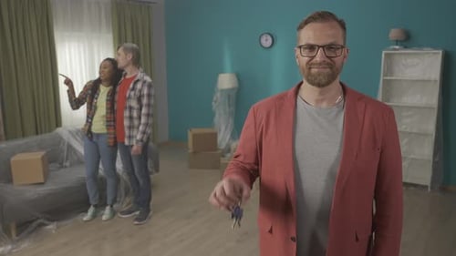 A Realtor or Real Estate Agent Shows the Key to the Apartment and Gives a Thumbs Up Portrait of a