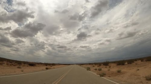 Driver point of view of a road through the vast landscape of the Mojave Desert - hyper lapse