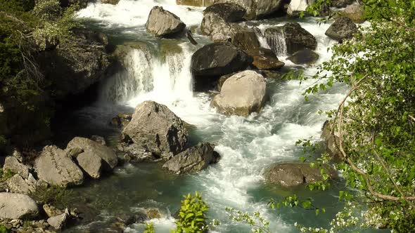 Beautiful alpine mountain river rushing over rocks in small waterfalls ...