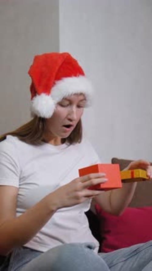 Excited Woman Opens Christmas Gift at Home