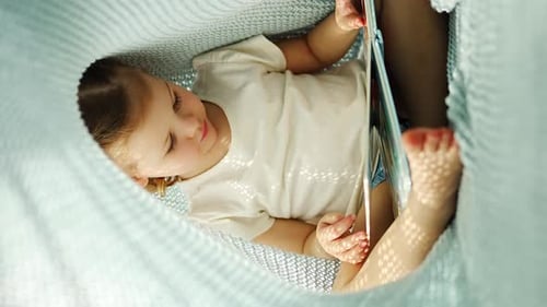 Young Girl Reading a Book under Blanket Fort
