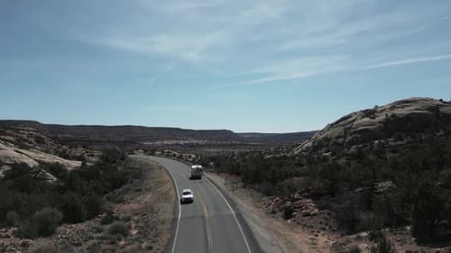 Drone track camper van truck on highway revealing Utah plateau landscape