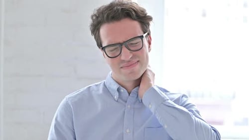 Young Adult Man Rubbing Neck in Pain