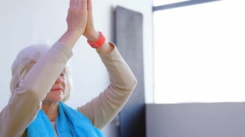 Senior Woman Meditating with Hands in Prayer Position
