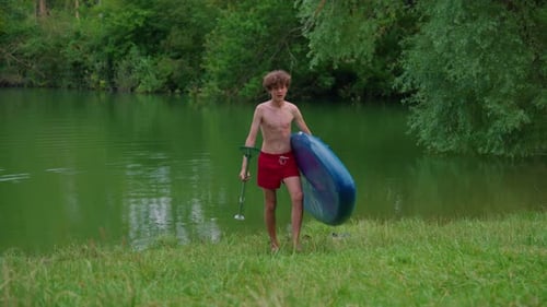 Alone Boy Floating on Stand Up Paddle Board in Lake in Summertime Standup Paddleboarding Surfer Rows