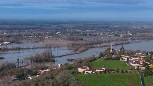 Aerial view of floodwaters submerge a landscape of vineyards and a lone building