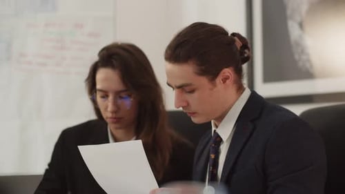 Young Professionals Reviewing Documents in Bright Modern Office