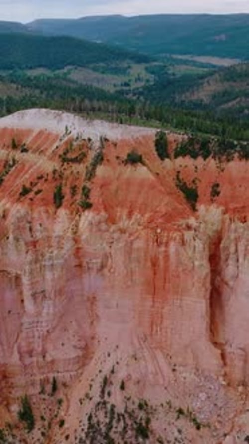 Stunning huge rock of coral color in Bryce National Park. Mountains overgrown with pine forest