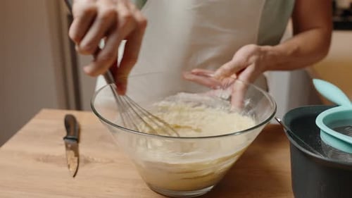 Whisking a Thick Batter in a Glass Bowl, Preparing for the Next Baking Step.
