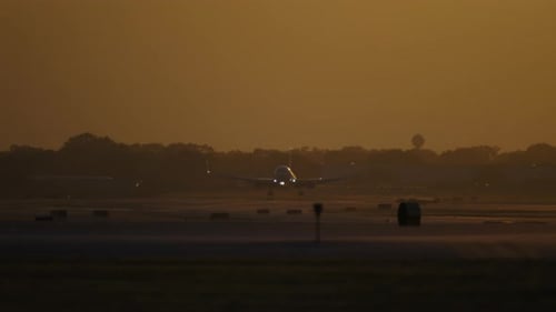 Jet Airplane Silhouette Approaching in Golden Sunset Prepare for Landing Slow Motion View