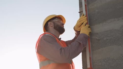 Slow motion of construction workers measuring a building under the sun at a construction site