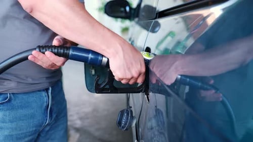 Man refueling his car at a gas station