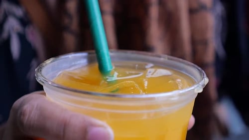 Close Up Stirring Cold Drink with Straw