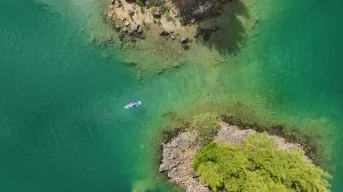 Aerial View Paddleboarding Adventure Through a Beautiful Green Canyon