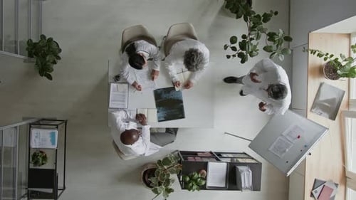 Chief Medical Doctor Discussing Difficult Patient Case with Staff in Office