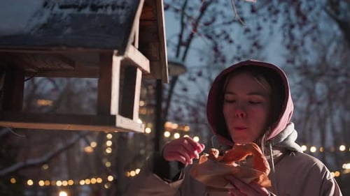 Young Student Feeding Birds in Bird House in Snowy Winter Park