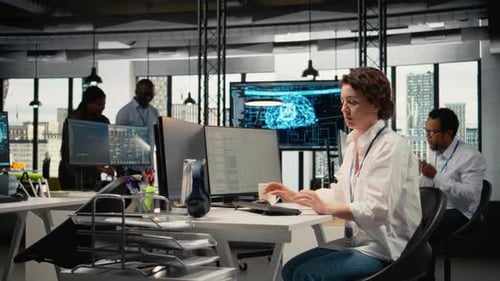 Woman Types at Computer in Open Office Setting