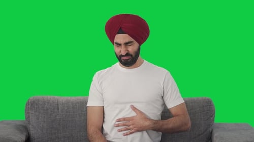 Sick Sikh Indian man suffering from acidity Green screen