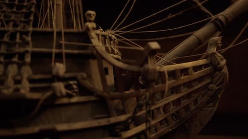 Panning along antique ship deck to mast.