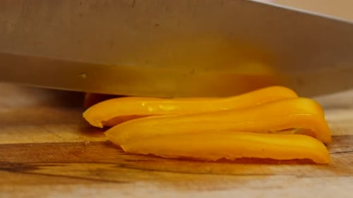 Slicing Fresh Yellow Bell Pepper on Cutting Board