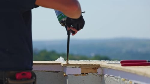 Primer plano de manos de un profesional de la construcción diligente al aplicar espuma en el sitio