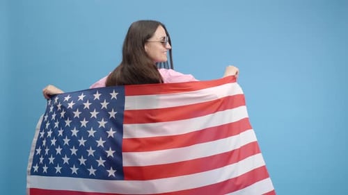 Woman Celebrates with American Flag and Sunglasses