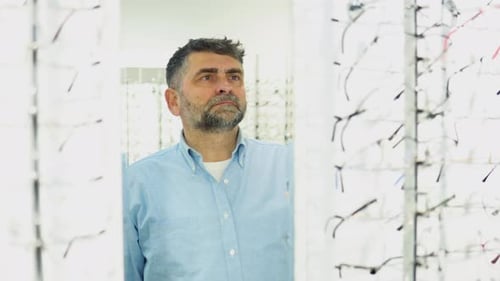Concepto de cuidado de la vista y la visión Hombre mayor de 50 y 60 años eligiendo anteojos en la tienda de óptica