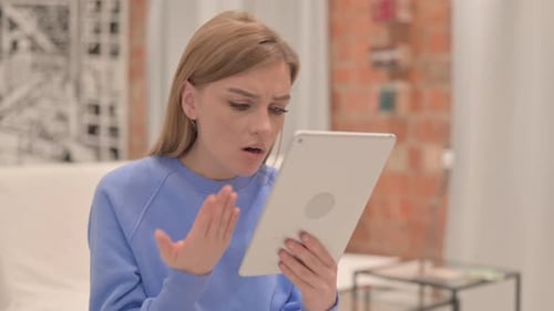 Woman Reacts to Content on Tablet Device Indoors