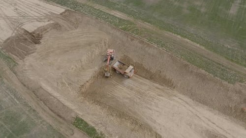 Excavator Fills Dump Truck in Rural Construction Area