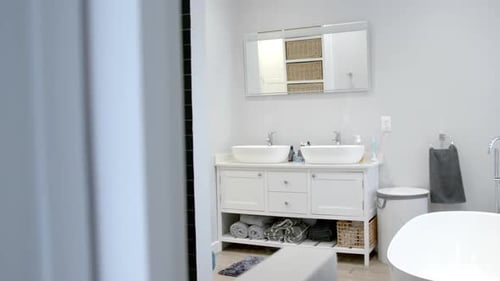 General view of bathroom with bathtub at home, mirror and washbasin, slow motion