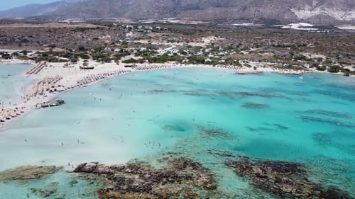 Voo aéreo revelando a paradisíaca praia de areia branca e água azul-turquesa de Elafonissi. A Europa