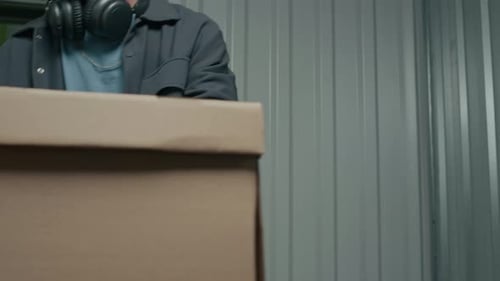 Homme déchargeant des boîtes dans une unité de libre-entreposage