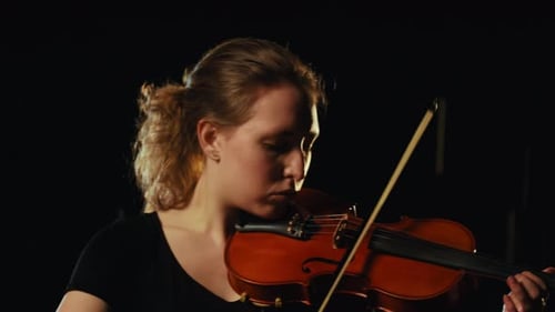 Focused Young Woman Plays the Violin Beautifully