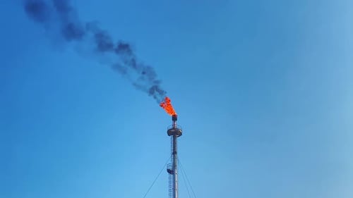 drone clip of the huge flame shooting from the chimney of a natural gas factory