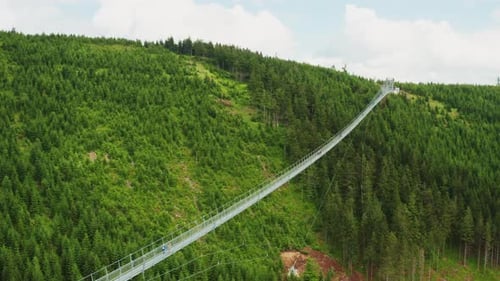 Tourists Walk on Long Suspension Sky Bridge in Mountains